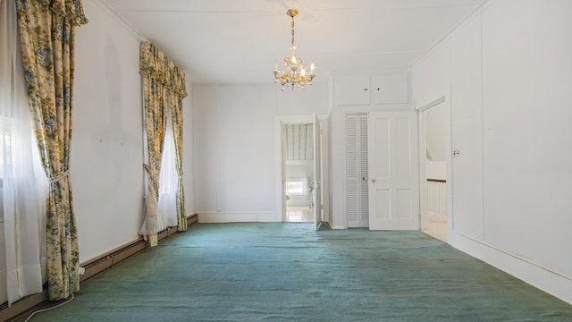 carpeted empty room featuring an inviting chandelier and a baseboard heating unit