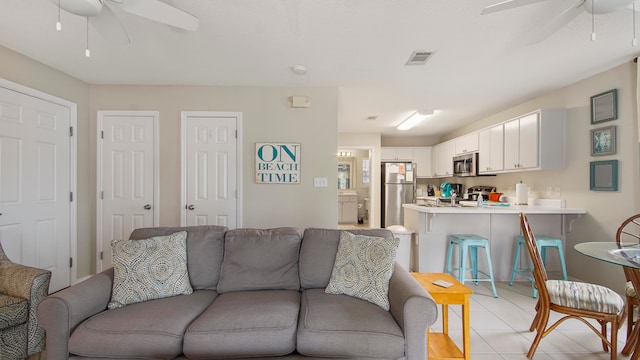 living room featuring ceiling fan and light tile flooring