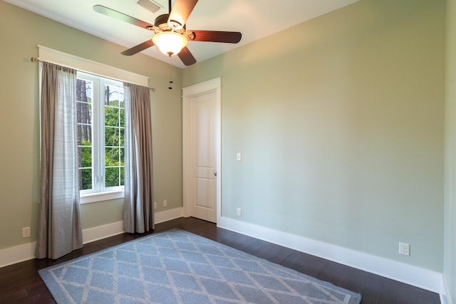 unfurnished bedroom featuring ceiling fan and dark hardwood / wood-style flooring