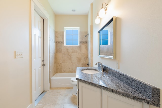 full bathroom with tiled shower / bath, toilet, tile floors, and vanity