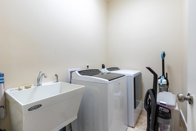 laundry area with light tile floors, washer and clothes dryer, sink, washer hookup, and hookup for an electric dryer