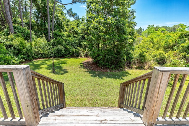 wooden deck featuring a lawn