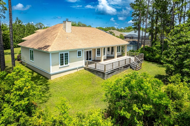 rear view of house with a deck and a lawn