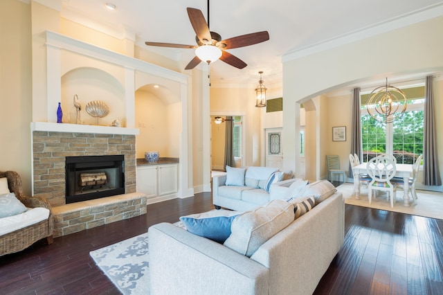 living room featuring ceiling fan with notable chandelier, ornamental molding, and dark hardwood / wood-style flooring