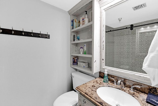 bathroom with vanity, toilet, and a tile shower