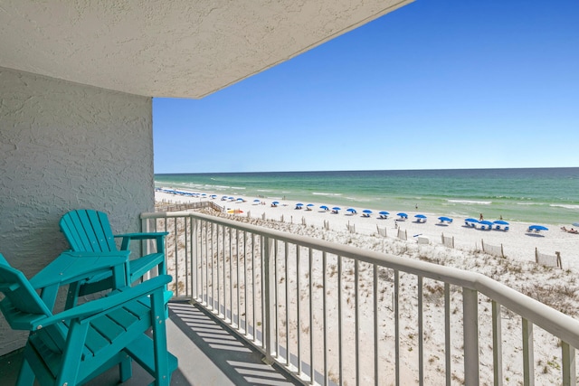 balcony with a water view and a beach view