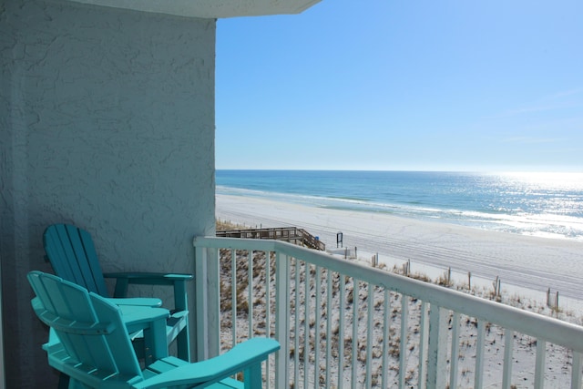 balcony featuring a water view and a beach view