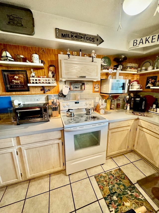 kitchen with light brown cabinetry, electric stove, and light tile floors