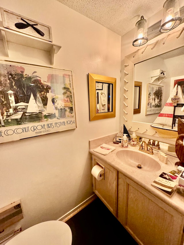 bathroom featuring vanity, toilet, and a textured ceiling