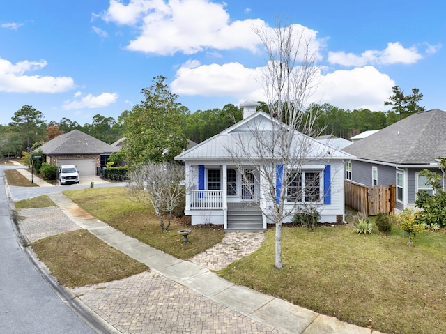 bungalow-style house featuring a garage, covered porch, and a front yard