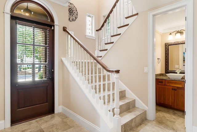 entryway with crown molding, a healthy amount of sunlight, and light tile floors