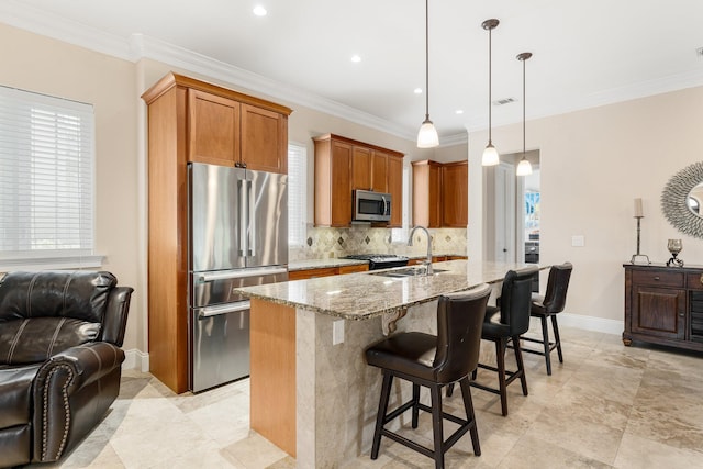 kitchen with light stone countertops, decorative light fixtures, appliances with stainless steel finishes, backsplash, and sink