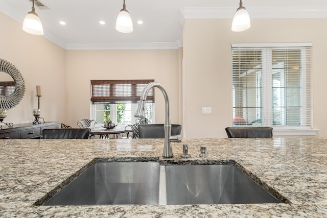 kitchen with ornamental molding, sink, and light stone counters