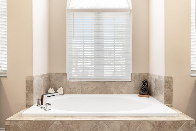 bathroom featuring a relaxing tiled bath