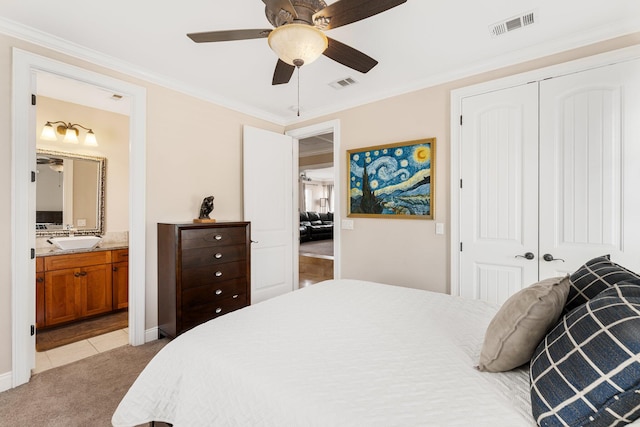 tiled bedroom with a closet, ceiling fan, ensuite bathroom, sink, and crown molding