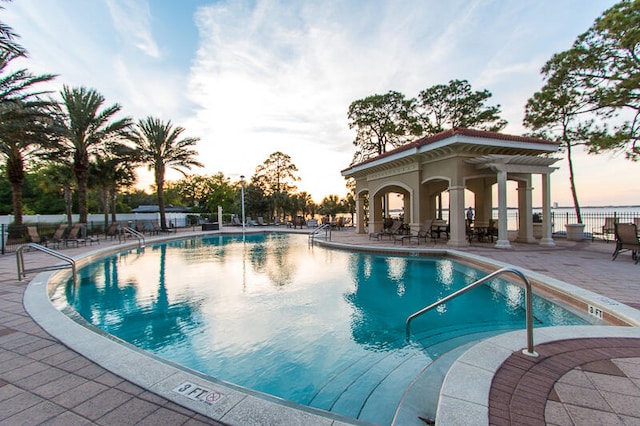 pool at dusk featuring a patio area