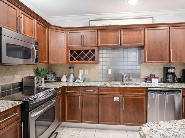 kitchen with sink, tasteful backsplash, appliances with stainless steel finishes, and light tile floors