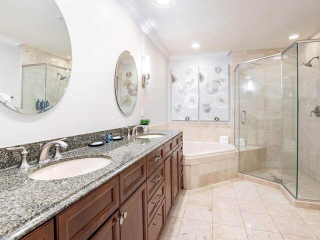 bathroom featuring vanity with extensive cabinet space, tile flooring, shower with separate bathtub, double sink, and ornamental molding