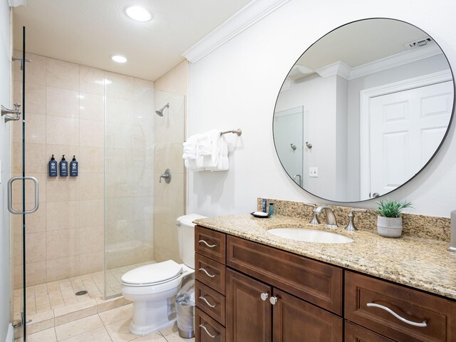 bathroom with vanity with extensive cabinet space, crown molding, tile floors, a shower with shower door, and toilet