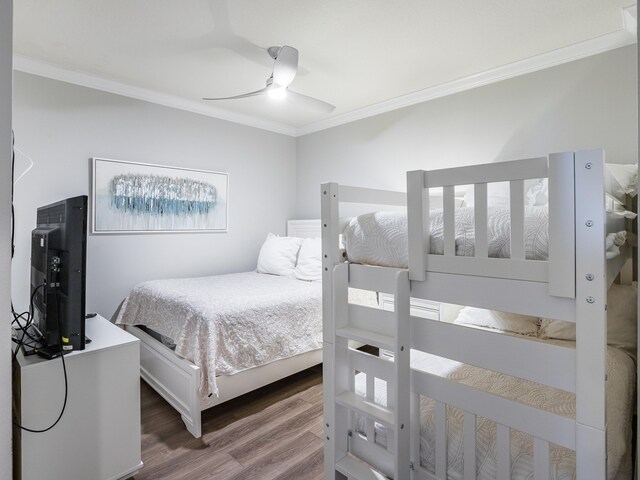 bedroom with hardwood / wood-style floors, ceiling fan, and crown molding