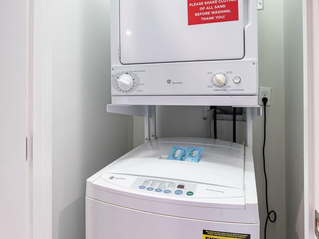 laundry room featuring stacked washer / drying machine