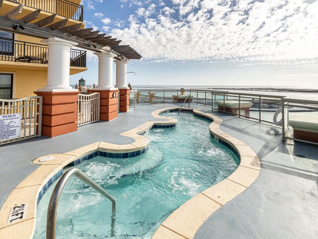 view of swimming pool featuring a hot tub