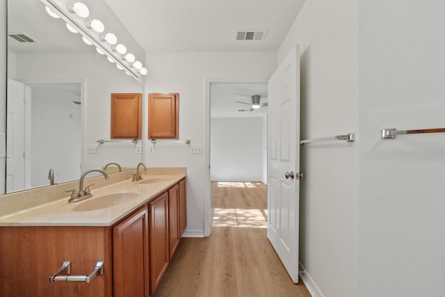 bathroom with wood-type flooring, double sink vanity, and ceiling fan