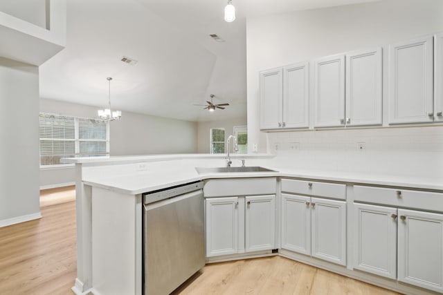 kitchen with stainless steel dishwasher, ceiling fan with notable chandelier, vaulted ceiling, and light hardwood / wood-style flooring