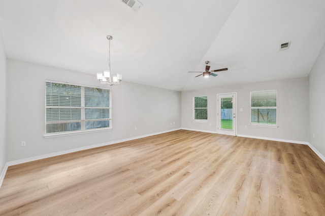 spare room with ceiling fan with notable chandelier, a healthy amount of sunlight, and light wood-type flooring