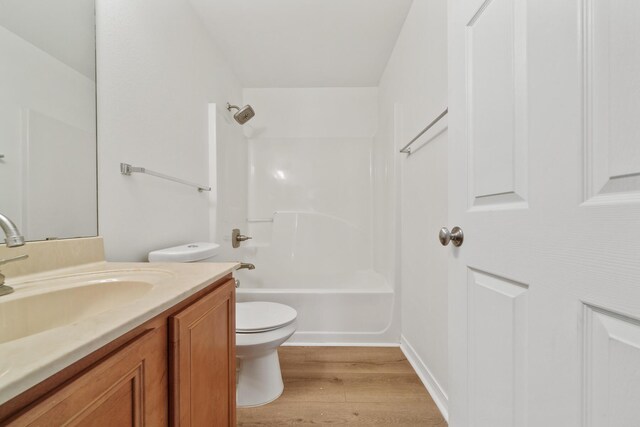 full bathroom with wood-type flooring, bathing tub / shower combination, toilet, and vanity