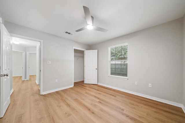 unfurnished bedroom with light hardwood / wood-style floors, a closet, and ceiling fan