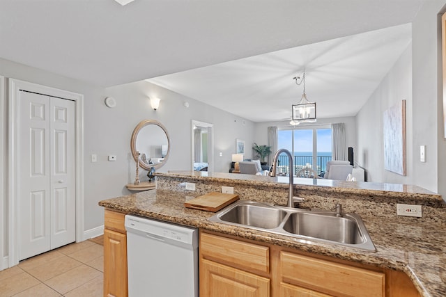 kitchen featuring sink, dishwasher, light tile floors, and light brown cabinets