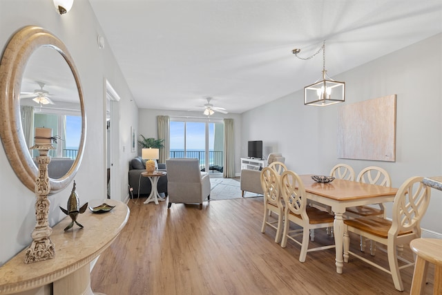 dining room with ceiling fan with notable chandelier and wood-type flooring