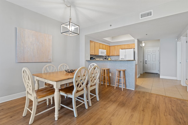 dining room featuring a chandelier and light tile flooring