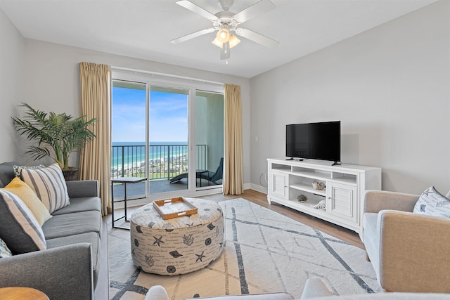 living room with a water view, ceiling fan, and hardwood / wood-style floors