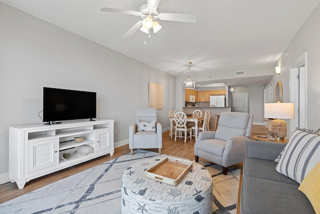 living room featuring ceiling fan and light hardwood / wood-style floors