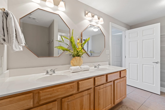 bathroom featuring dual sinks, tile flooring, and oversized vanity