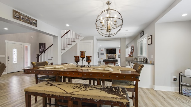 dining room featuring light wood-type flooring and an inviting chandelier