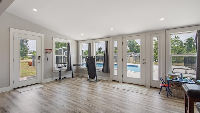 doorway featuring plenty of natural light, light hardwood / wood-style flooring, and vaulted ceiling