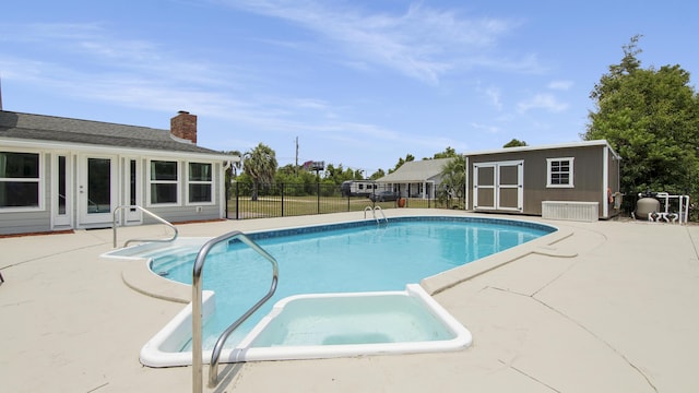 view of pool featuring a patio and a storage unit