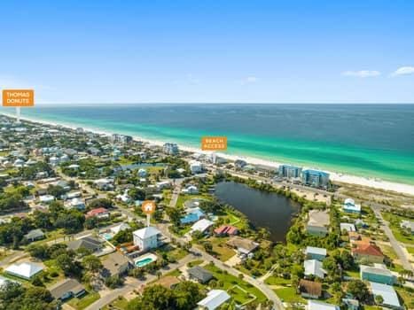 birds eye view of property featuring a water view and a beach view