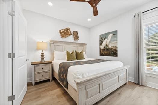 bedroom featuring multiple windows, ceiling fan, and light wood-type flooring