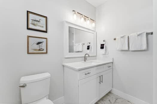 bathroom featuring tile floors, vanity, and toilet