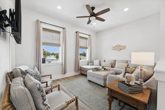 living room featuring wood-type flooring and ceiling fan