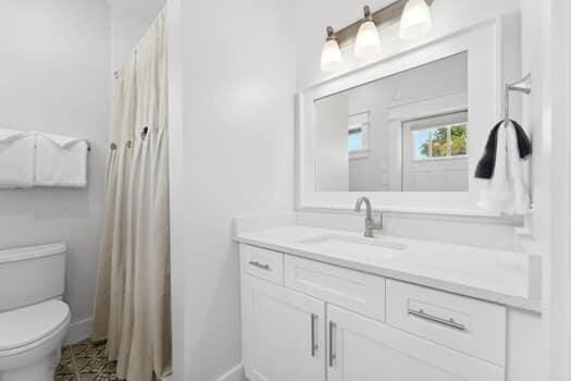 bathroom with vanity, tile floors, and toilet