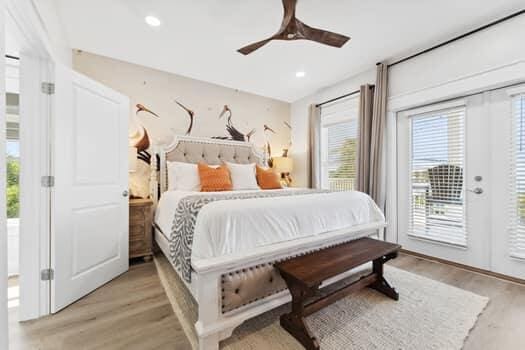 bedroom featuring light hardwood / wood-style flooring, ceiling fan, access to outside, and multiple windows