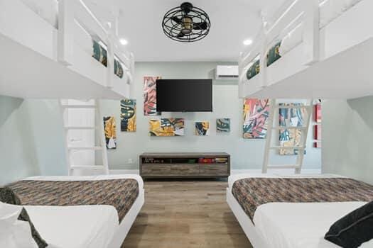 bedroom with wood-type flooring, a towering ceiling, and an AC wall unit