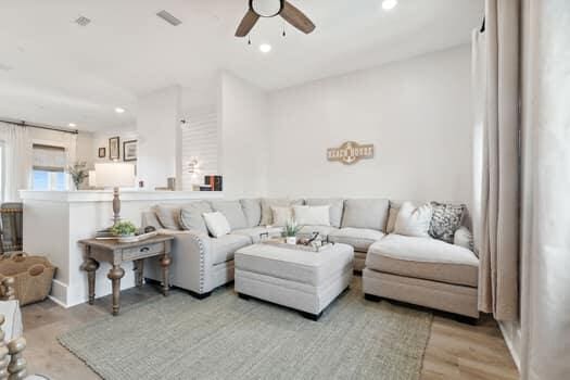 living room featuring ceiling fan and light wood-type flooring