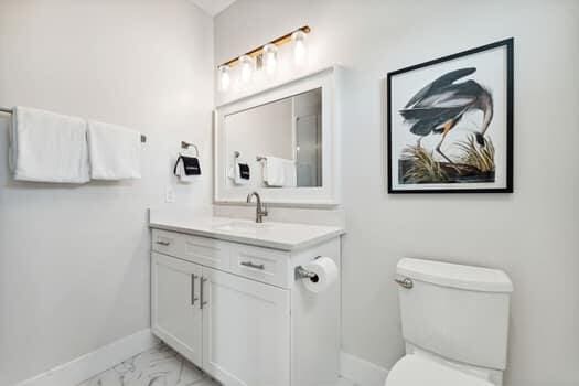 bathroom featuring tile floors, vanity, and toilet