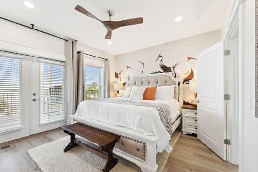 bedroom featuring french doors, light hardwood / wood-style flooring, ceiling fan, and access to exterior